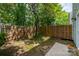 This backyard features a wood fence, large tree, and small patio area at 7309 Pebblestone Dr # D, Charlotte, NC 28212