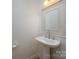 A pedestal sink with a framed mirror in a half bathroom at 7309 Pebblestone Dr # D, Charlotte, NC 28212