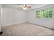 Carpeted bedroom with a ceiling fan and a window offering natural light at 7309 Pebblestone Dr # D, Charlotte, NC 28212