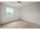 Small bedroom with carpet, a window with natural light, and painted in white at 7309 Pebblestone Dr # D, Charlotte, NC 28212