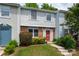 Charming two-story townhome with brick accents, a well-manicured lawn, and a bright red front door at 7309 Pebblestone Dr # D, Charlotte, NC 28212
