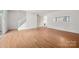 Bright living room featuring wood floors, staircase, coat closet, and window to dining area at 7309 Pebblestone Dr # D, Charlotte, NC 28212