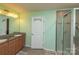 Bathroom featuring dual vanities, shower with glass door, and modern light fixtures at 7412 Greene Mill Sw Ave, Concord, NC 28025