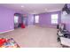 Spacious bonus room painted purple features ample natural light, an open floor plan, and play equipment for  at 7412 Greene Mill Sw Ave, Concord, NC 28025