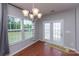 Sunlit dining area with chandelier and french doors that offer outdoor access, perfect for entertaining or Gathering meals at 7412 Greene Mill Sw Ave, Concord, NC 28025