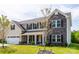 Charming two-story home with stone accents, a front porch, and attached two car garage at 7412 Greene Mill Sw Ave, Concord, NC 28025