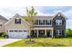 Two story home features a blend of vinyl siding and stone facade with neat landscaping at 7412 Greene Mill Sw Ave, Concord, NC 28025