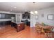 Spacious kitchen with dark cabinets, stainless appliances, granite counters, and an adjacent dining area on hardwood floors at 7412 Greene Mill Sw Ave, Concord, NC 28025