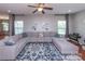 A well-lit living room featuring a large sectional sofa and view to the manicured lawn at 7412 Greene Mill Sw Ave, Concord, NC 28025