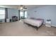Bright main bedroom featuring a ceiling fan, bedside tables, and a chair near the window at 7412 Greene Mill Sw Ave, Concord, NC 28025