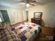 Spacious bedroom with hardwood floors, a ceiling fan, and a large closet at 7431 Idlewild Rd, Charlotte, NC 28212