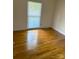 Bright bedroom featuring hardwood flooring and natural light from a window with white blinds at 7431 Idlewild Rd, Charlotte, NC 28212