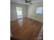 Bright bedroom with hardwood floors, a ceiling fan, and two windows at 7431 Idlewild Rd, Charlotte, NC 28212