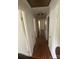Hallway with wood-look flooring and multiple white doors at 7431 Idlewild Rd, Charlotte, NC 28212