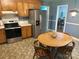 Open eat-in kitchen with stainless steel appliances, wood cabinets, and breakfast table at 7431 Idlewild Rd, Charlotte, NC 28212