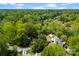Sprawling aerial view of the community with lush trees, homes, and a distant city skyline on the horizon at 7905 Quail Field Dr, Charlotte, NC 28227