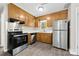 Functional kitchen with stainless steel appliances, wood cabinets, and a view of the backyard at 7905 Quail Field Dr, Charlotte, NC 28227