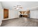 Open-concept living room showcasing modern gray flooring leading to the kitchen with stainless steel appliances at 7905 Quail Field Dr, Charlotte, NC 28227