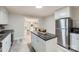 Bright kitchen featuring stainless steel appliances, kitchen island, and gray vinyl flooring at 828 Richard Ave, Kannapolis, NC 28081