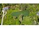 Lush aerial view of large lot with verdant lawns, mature trees, and private pond at 8670 Arbor Oaks Cir, Concord, NC 28027