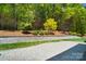 Serene backyard featuring a stone patio, manicured lawn, and lush greenery at 8670 Arbor Oaks Cir, Concord, NC 28027