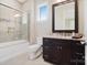 Bathroom with shower and tub combo, dark wood vanity, and updated fixtures at 8670 Arbor Oaks Cir, Concord, NC 28027