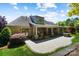Back exterior elevation of a beautiful brick house, patio, and landscaped yard at 8670 Arbor Oaks Cir, Concord, NC 28027