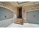 Garage entry featuring brick stairs, iron railing and two car garage with neutral colored doors at 8670 Arbor Oaks Cir, Concord, NC 28027