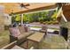 Inviting outdoor living space with a stone fireplace, covered area, and serene backyard view at 8670 Arbor Oaks Cir, Concord, NC 28027