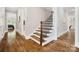 Staircase with hardwood steps and an iron railing with hardwood handrail at 8670 Arbor Oaks Cir, Concord, NC 28027