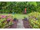 Lush backyard garden with stone pathway, colorful flowers, and abundant greenery at 9652 Wheatfield Rd, Charlotte, NC 28277