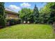 Serene backyard with green lawn, mature trees, and two Adirondack chairs for relaxing outdoors at 9652 Wheatfield Rd, Charlotte, NC 28277