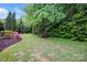 Lush backyard featuring mature trees, flowering plants, and green lawn, perfect for outdoor enjoyment at 9652 Wheatfield Rd, Charlotte, NC 28277