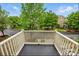 Balcony with a white railing, overlooking a neighborhood street with tree-lined streets and houses under a sunny sky at 9652 Wheatfield Rd, Charlotte, NC 28277