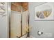 Stylish walk-in shower with tiled walls, glass door, decorative elements, and beach-themed artwork at 9652 Wheatfield Rd, Charlotte, NC 28277