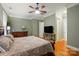 Comfortable bedroom with green walls, hardwood floors, and a ceiling fan and view of a TV at 9652 Wheatfield Rd, Charlotte, NC 28277