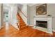 Inviting hallway with hardwood floors, a staircase, and a fireplace in the background at 9652 Wheatfield Rd, Charlotte, NC 28277
