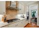 Modern kitchen featuring stainless steel appliances, a cooktop, and ample cabinet and counter space at 9652 Wheatfield Rd, Charlotte, NC 28277