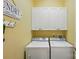 Functional laundry room with white cabinets and modern washer and dryer units at 9652 Wheatfield Rd, Charlotte, NC 28277