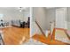 Open doorway to a living room featuring a gray sectional, hardwood floors, and a staircase leading to the lower level at 9652 Wheatfield Rd, Charlotte, NC 28277