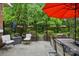 Comfortable outdoor seating beneath a red umbrella in a serene patio area with lush greenery at 9652 Wheatfield Rd, Charlotte, NC 28277