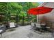 Inviting patio with outdoor seating, a red umbrella, and landscaped surroundings at 9652 Wheatfield Rd, Charlotte, NC 28277