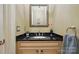 Stylish powder room with a black granite countertop and a decorative mirror at 9652 Wheatfield Rd, Charlotte, NC 28277