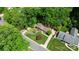 An aerial view shows a brick house surrounded by mature trees at 1024 Regency Dr, Charlotte, NC 28211