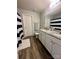 Well-lit bathroom with double sinks, granite countertop, white cabinets, and a shower/tub with a striped curtain at 1070 Glenbriar Ct, Woodleaf, NC 27054
