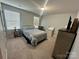Cozy bedroom with neutral walls, carpeted floors, a queen-sized bed, and a dresser near a window at 1070 Glenbriar Ct, Woodleaf, NC 27054