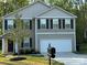 Charming two-story home features a two-car garage, complemented by a landscaped front yard and dark shutters at 1070 Glenbriar Ct, Woodleaf, NC 27054