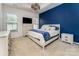 Cozy bedroom featuring a blue accent wall, tray ceiling, and plush carpeting throughout the space at 11062 Discovery Nw Dr, Concord, NC 28027