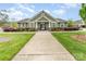 View of the community clubhouse exterior with lawn and landscaping at 11062 Discovery Nw Dr, Concord, NC 28027