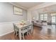 Open-concept dining area with hardwood floors, a gray table set and open view to the living area at 11062 Discovery Nw Dr, Concord, NC 28027